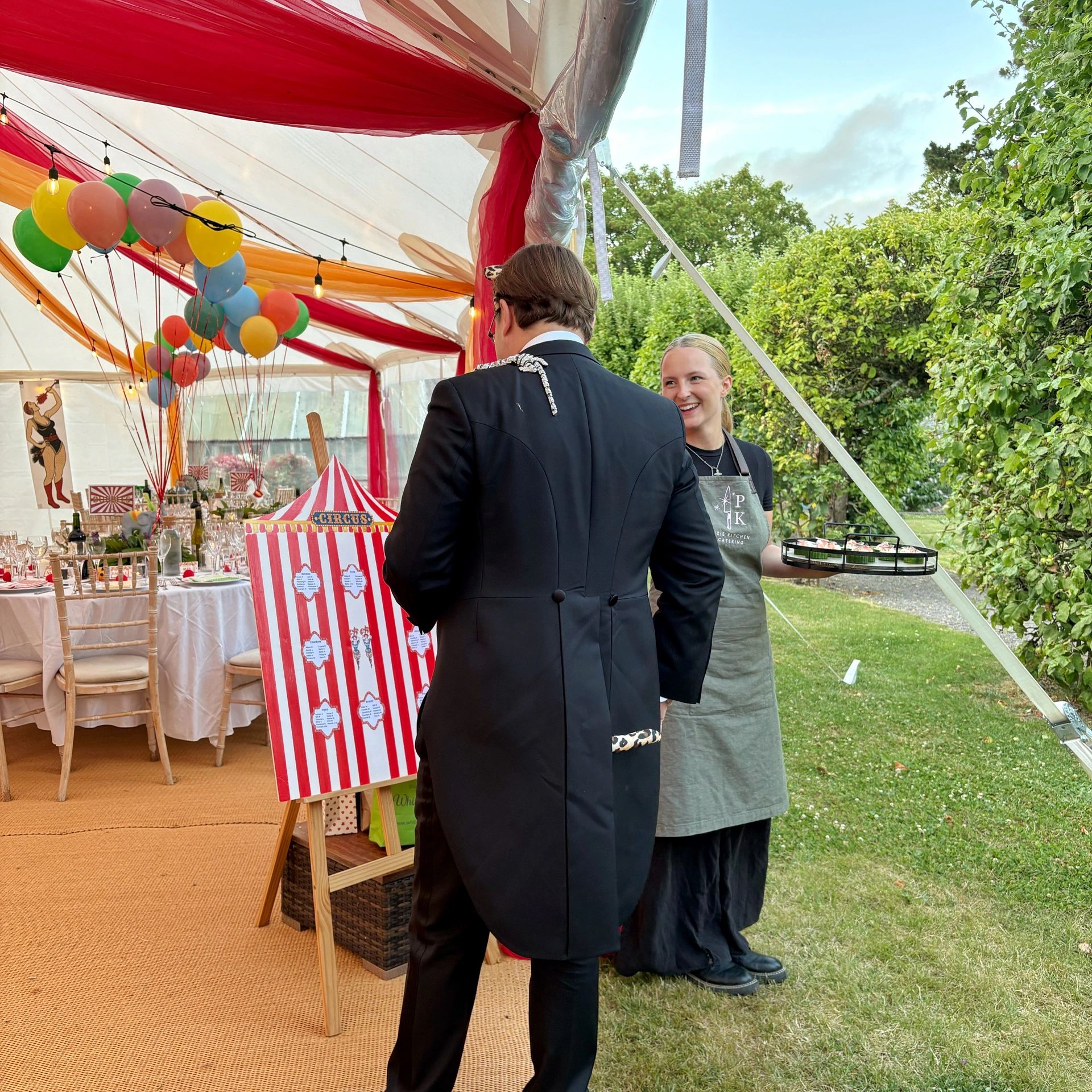 Two people at a circus-themed party with balloons and decorations.