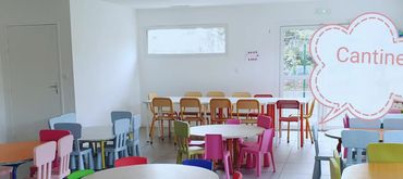 Colorful children's chairs and tables in a bright dining room.