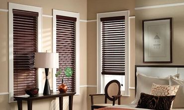 Dark-stained wood window blinds installed against white trim for a high-contrast look