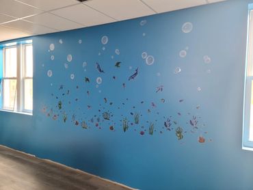 "Under the sea" themed wall in the laundromat children's play area
