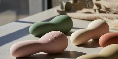 Colorful, smooth, abstract-shaped objects on a sunlit surface.