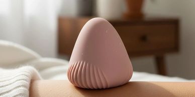 A pink massage device on a person's back in a cozy room.