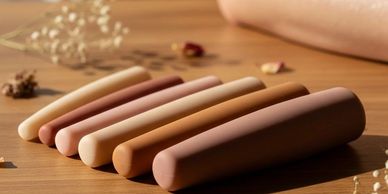 Set of six differently colored rounded sticks on a wooden surface.