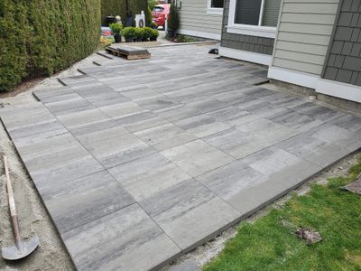 Professional paver installation crew in Richmond BC building a modern backyard patio