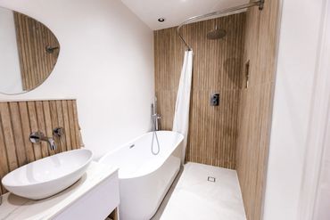 freestanding bath separate wet room waterfall overhead shower wood slated tiles wall hung vanity uni