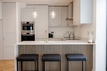 breakfast bar bar stools pendant lights wood slated acoustic panels howdens kitchen modern