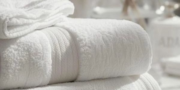 Soft, white folded towels stacked neatly.