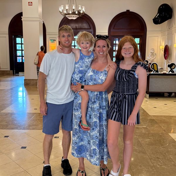 Happy family posing in a bright lobby.