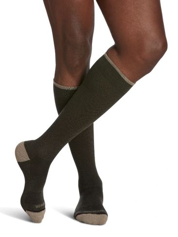 Person wearing dark knee-high socks with beige toes and heels.