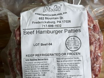 Package of beef hamburger patties with label and safety instructions.