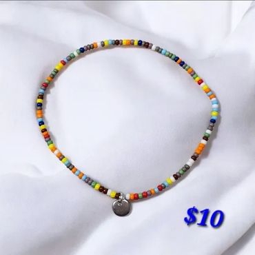 Colorful beaded necklace with a small silver charm, priced at $10.