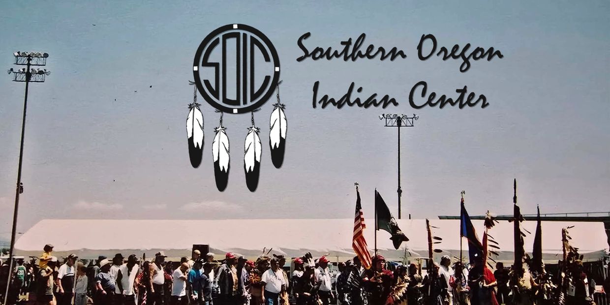 Gathering at the Southern Oregon Indian Center event with flags and traditional attire.