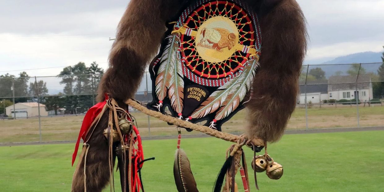 Native American regalia with a dreamcatcher and feathers.