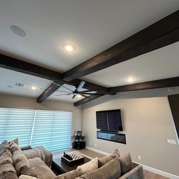 Dark chocolate faux wood beams, sleeves created to cover existing drywalled beams