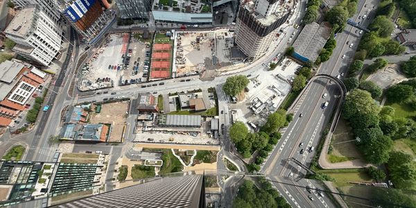 Aerial view of urban construction and roads with high-rise buildings and greenery.