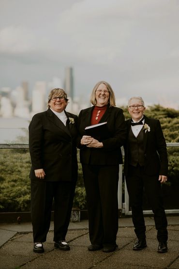Three persons with a black suit posing for a picture