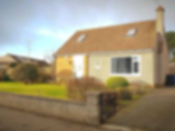 A blurry image of a suburban house with a front yard and driveway.