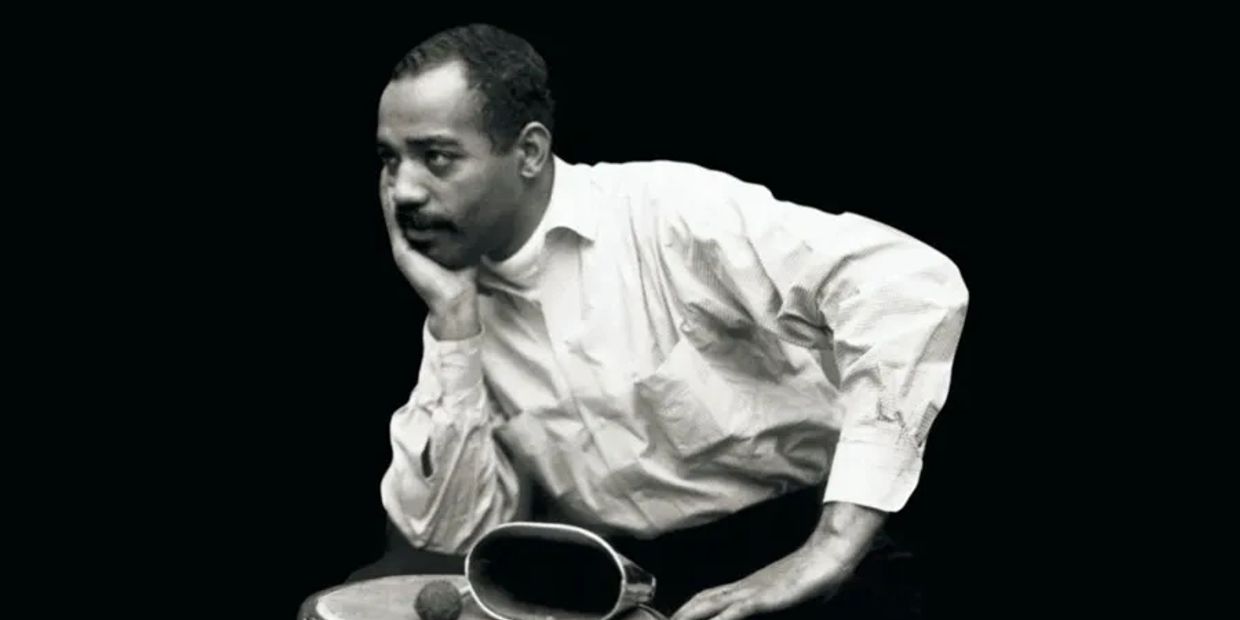 Black and white photo of a thoughtful man resting his face on his hand.