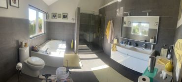 Bright and modern bathroom with gray tiles and yellow accents.