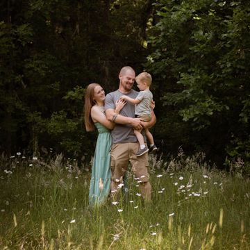 Happy family enjoying a sunny day outdoors in a wildflower meadow.