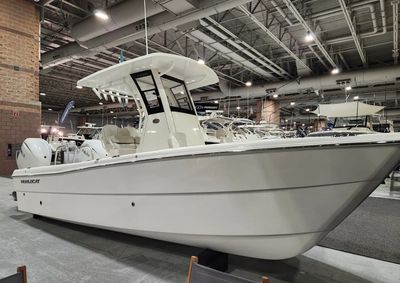 Sleek white fishing boat displayed indoors at a boat show.