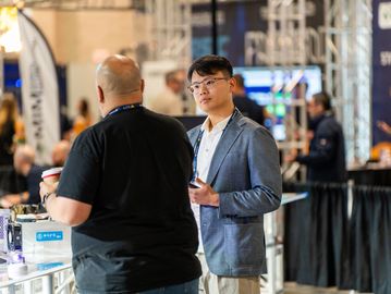 Two men engaging in conversation at a tech event.