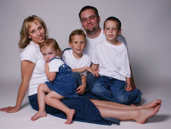 Family of five posing together in casual outfits.