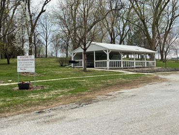 A white pavilion and a welcome sign at Herman Park with trees around.