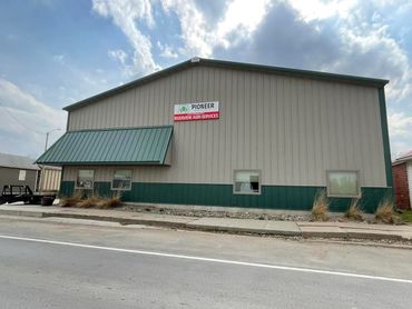 A commercial building with a sign for Riverview Agri-Services under a partly cloudy sky.