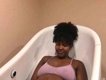 Image of a pregnant mother in birth, labouring in a tub in the hospital