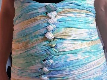 Woman in postpartum with a bengkung belly bonding wrap on her stomach