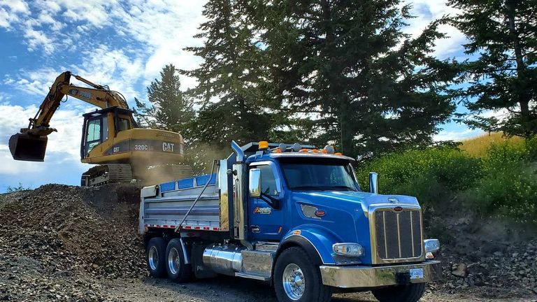Stobbe Excavating Cat excavator loading Peterbilt dump truck with rock