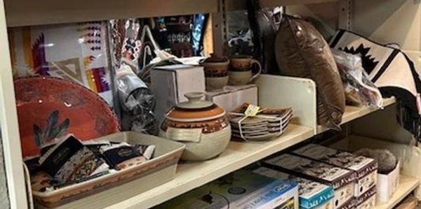 Shelf with Native American pottery, textiles, and decorative items.