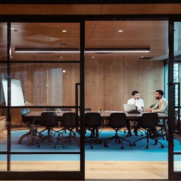 Two men having a discussion in a modern conference room.