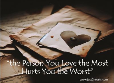 A heart-shaped note on old papers with a quote about love and hurt.