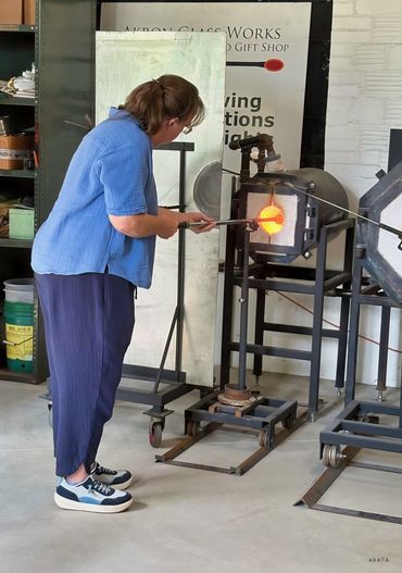 Putting the pipe of molten glass in for reheating