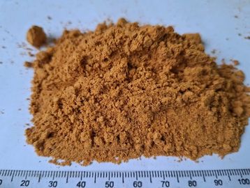 A pile of brown powder on a white surface with a ruler.