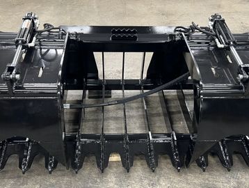 Heavy-duty black grapple attachment for machinery with hydraulic cylinders.