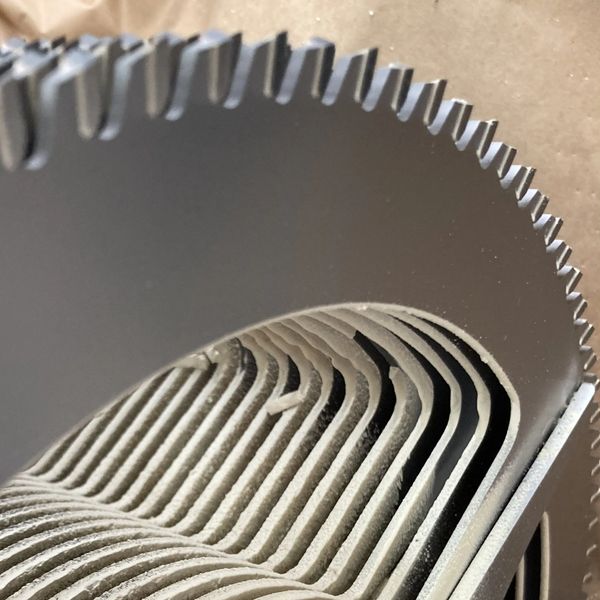 Close-up of a metal fan blade with curved fins.