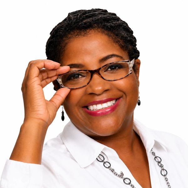 Smiling woman adjusting her glasses.