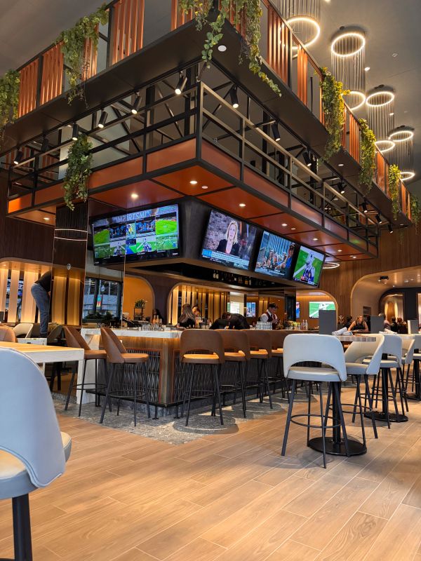 Modern sports bar with multiple TV screens and stylish seating.