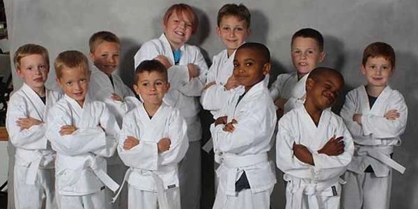Young boys posing in white martial arts uniforms with white belts.