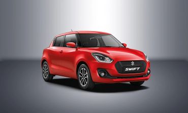 Red Suzuki Swift car angled front view.