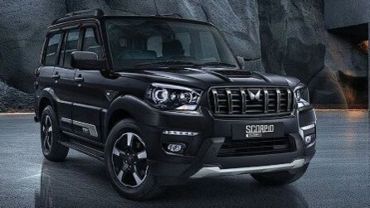 Black Mahindra Scorpio SUV parked on a reflective surface.
