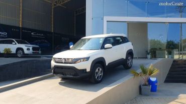 White Suzuki SUV parked outside a showroom.