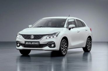 White Suzuki Baleno car in a studio setting.