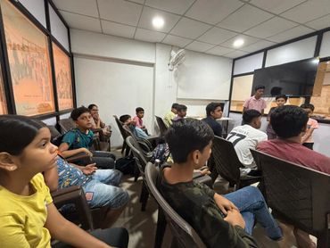 A group of young people attentively listening in a classroom setting.