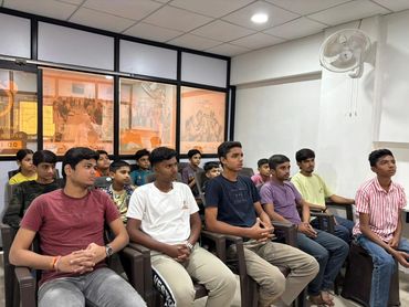 A group of young men sitting attentively in a classroom setting.
