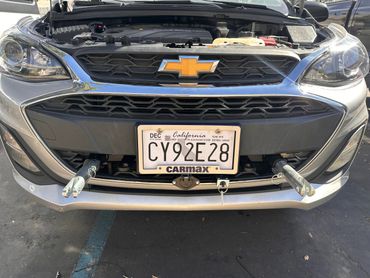 Front view of a Chevrolet car with license plate and towing hooks.