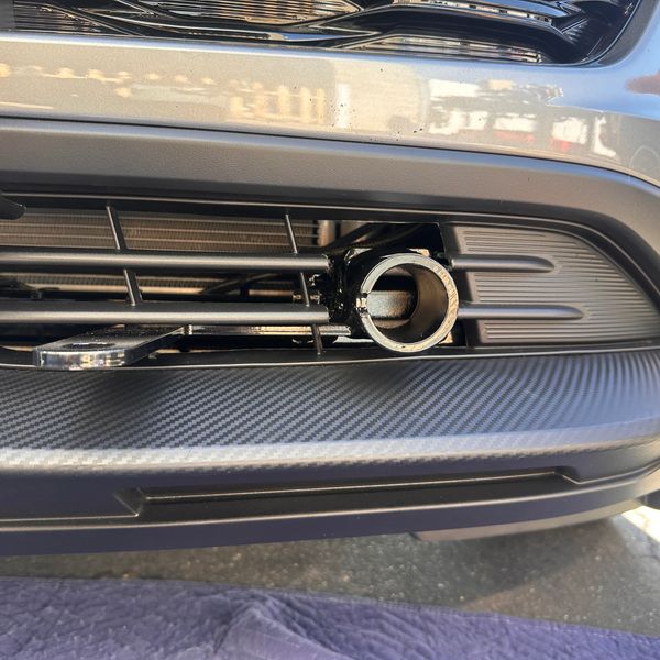 Close-up of a car's front grille with a metal attachment.